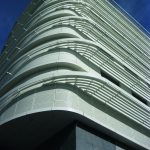 Sun protection fabric and wall cladding follows the curve of the building